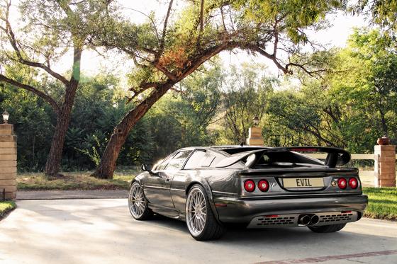 AI-generated preview of a dark grey 2000 Lotus Esprit V8, rear left view, on Splux SA-04 wheels