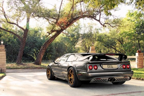 AI-generated preview of a dark grey 2000 Lotus Esprit V8, rear left view, on Splux SA-05 wheels