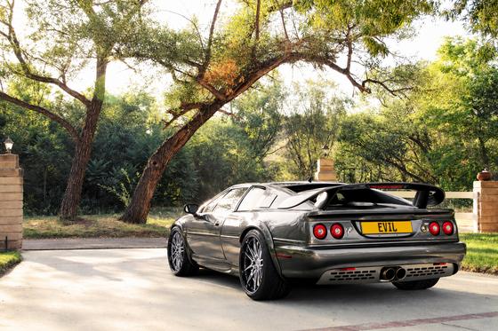 AI-generated preview of a dark grey 2000 Lotus Esprit V8, rear left view, on Splux SD-01 wheels