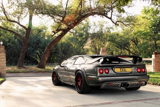 AI-generated preview of a dark grey 2000 Lotus Esprit V8, rear left view, on Splux SD-04 wheels