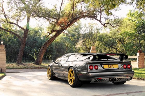 AI-generated preview of a dark grey 2000 Lotus Esprit V8, rear left view, on Splux SD-11 wheels