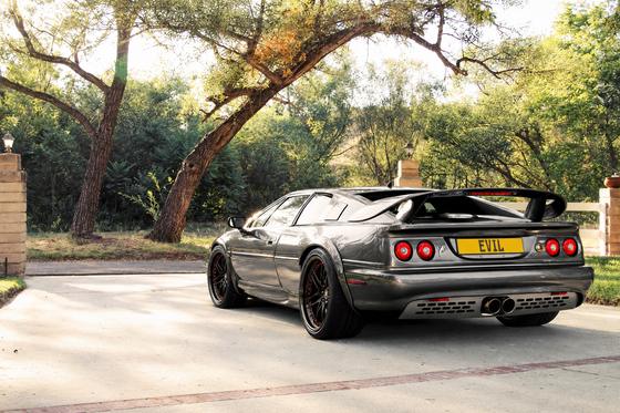 AI-generated preview of a dark grey 2000 Lotus Esprit V8, rear left view, on Splux SD-15 wheels