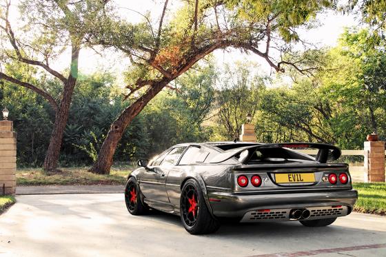 AI-generated preview of a dark grey 2000 Lotus Esprit V8, rear left view, on Splux SL-C10 wheels