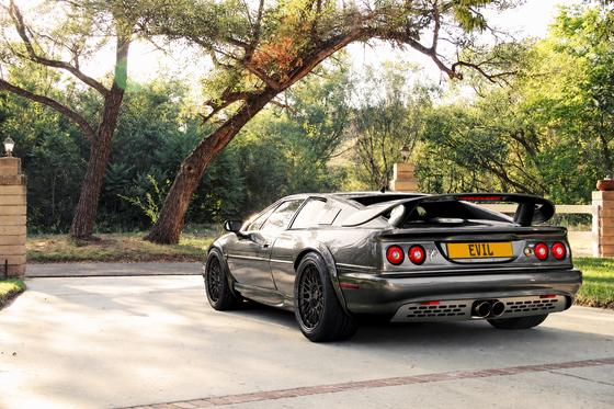 AI-generated preview of a dark grey 2000 Lotus Esprit V8, rear left view, on Splux SL-C11 wheels
