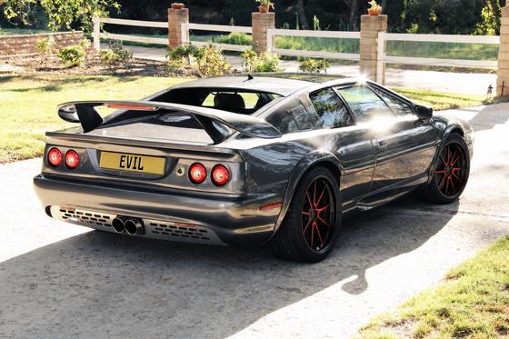 AI-generated preview of a dark grey 2000 Lotus Esprit V8, rear right view, on Splux SD-04 wheels