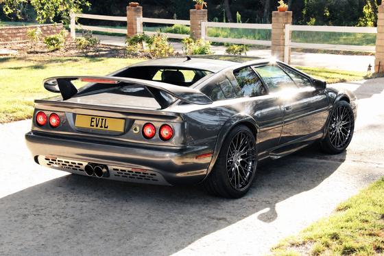 AI-generated preview of a dark grey 2000 Lotus Esprit V8, rear right view, on Splux SD-12 wheels