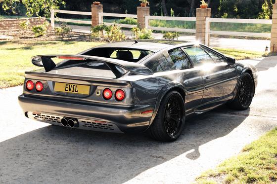 AI-generated preview of a dark grey 2000 Lotus Esprit V8, rear right view, on Splux SD-14 wheels