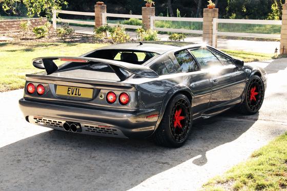 AI-generated preview of a dark grey 2000 Lotus Esprit V8, rear right view, on Splux SL-C10 wheels