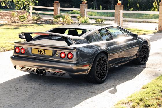 AI-generated preview of a dark grey 2000 Lotus Esprit V8, rear right view, on Splux SL-C11 wheels